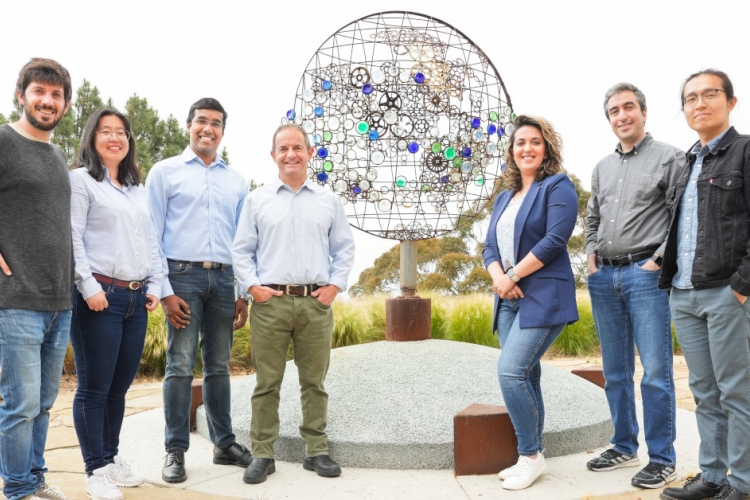  From the left, Jorge Baño-Medina, Zhiqi Yang, Agniv Sengupta, Luca Delle Monache, Vesta Afzali Gorooh, Mohammadvaghef Ghazvinian and Weiming Hu, members of the Machine Learning Team at the Center for Western Weather and Water Extremes, gather around a sculpture entitled "Atmospheric Rivers," created by artist Oscar Romo, outside Nierenberg Hall at Scripps Institution of Oceanography. The team is using AI to improve the prediction of atmospheric rivers, which are expected to intensify as the climate continu